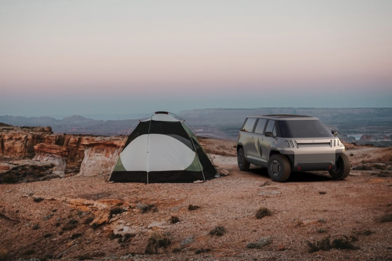 TELO truck parked beside a green tent with the Grand Canyon in the background at sunset.