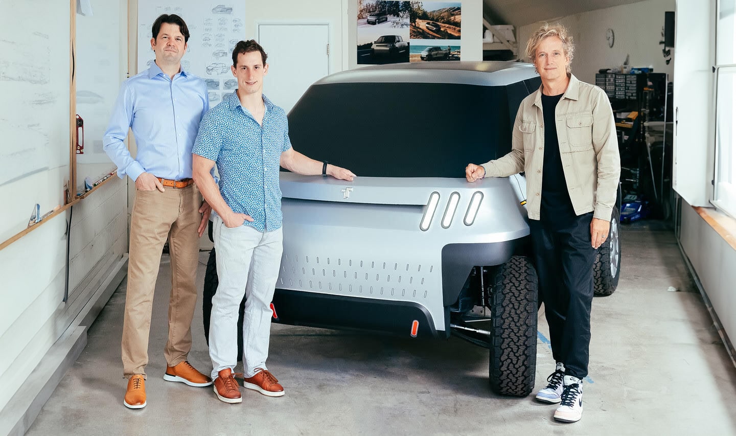 TELO Truck founders standing in front of TELO MT1 prototype in a small warehouse.